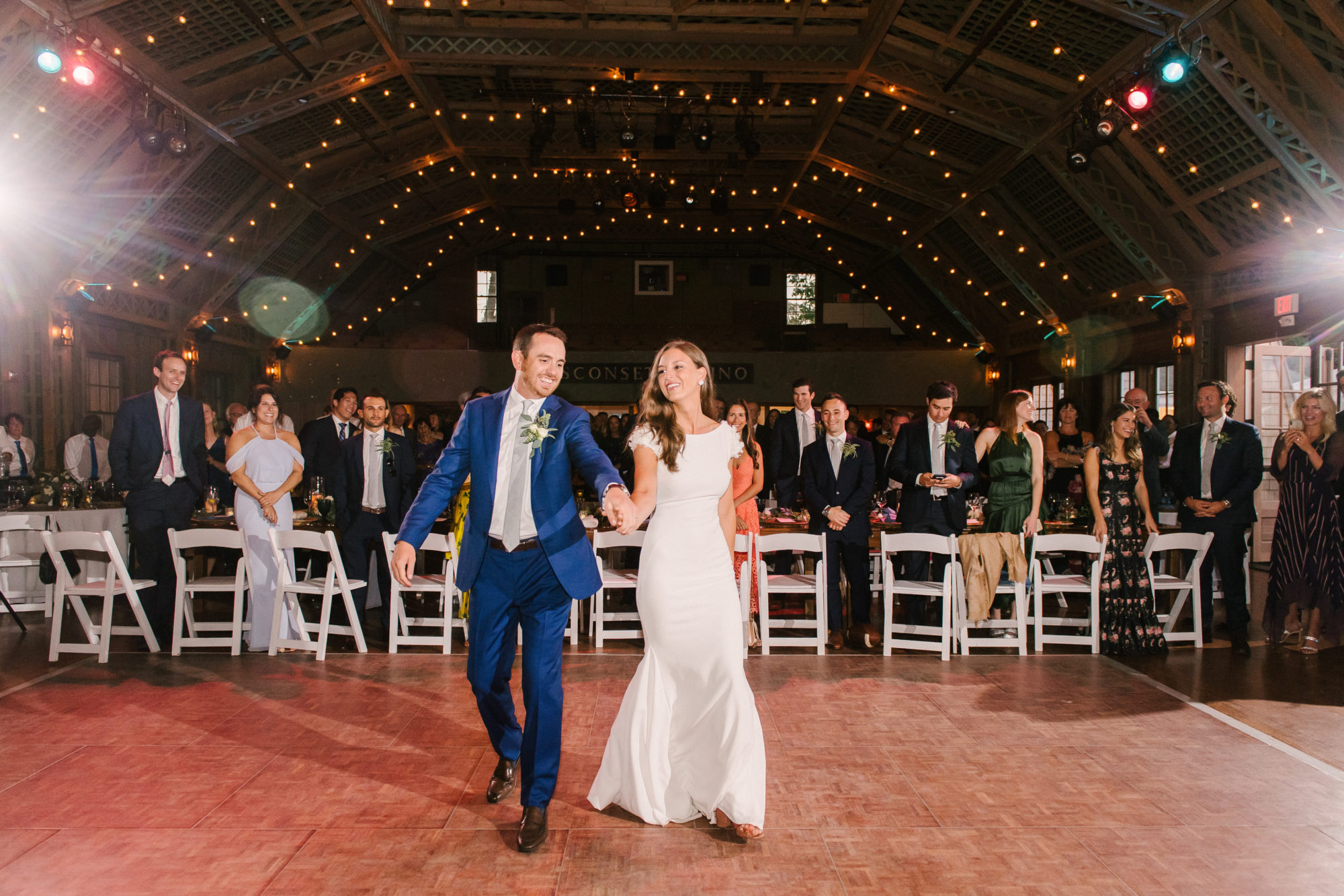 Wedding Photography Tips: How to Take Gorgeous Indoor Wedding Photos by popular New England photographer, Shannon Shipman: image of a bride and groom walking out onto the dance floor. 