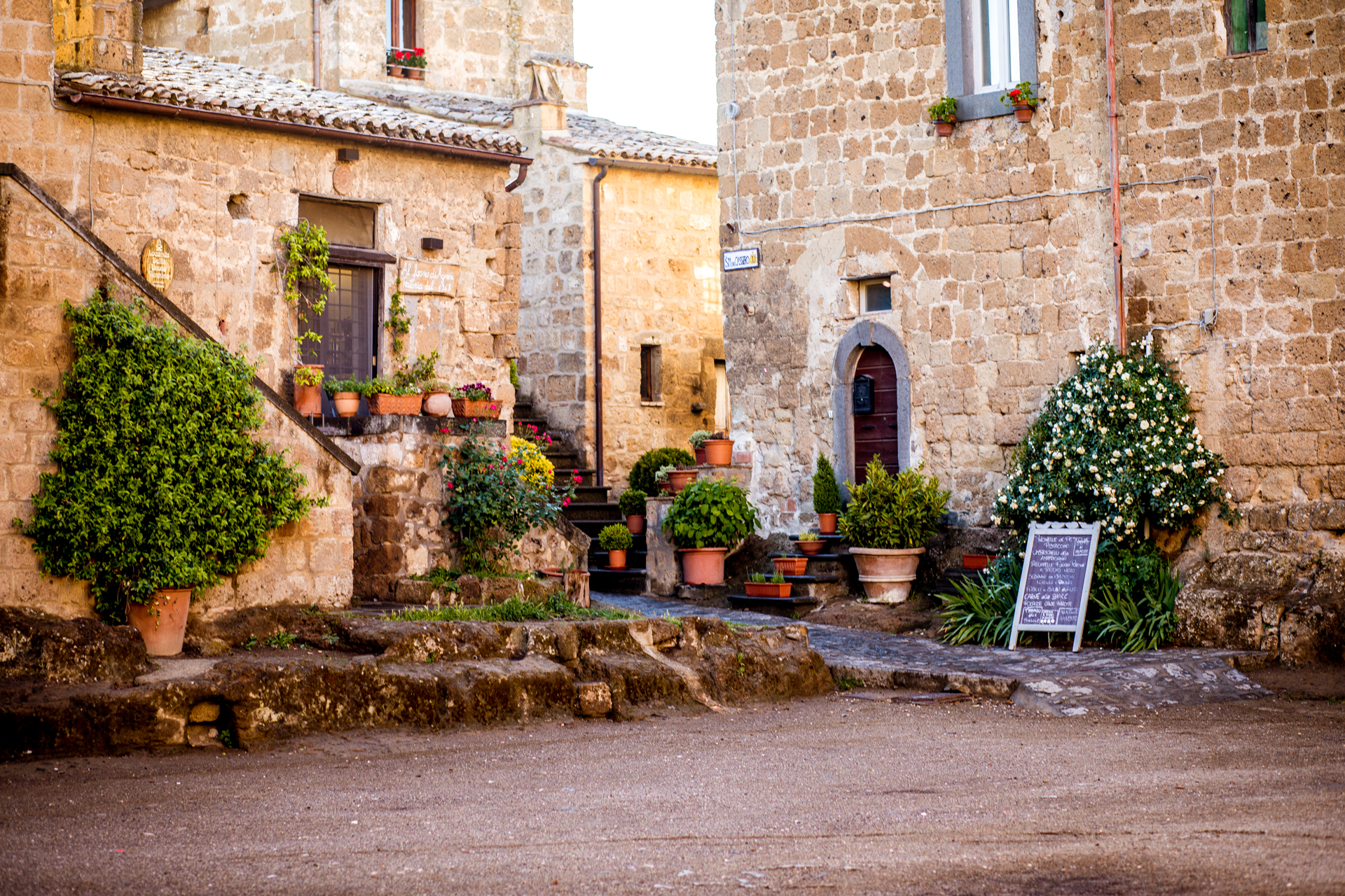Garden Inspiration: Garden Ideas From Tuscany | Tuscany Garden Ideas by popular New England travel blogger, Shannon Shipman: image of terracotta pots on walls and stone steps. 