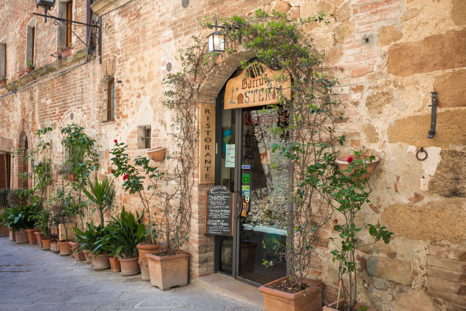 Garden Inspiration: Garden Ideas From Tuscany | Tuscany Garden Ideas by popular New England travel blogger, Shannon Shipman: image of a terracotta pots lined up along a stone building. 