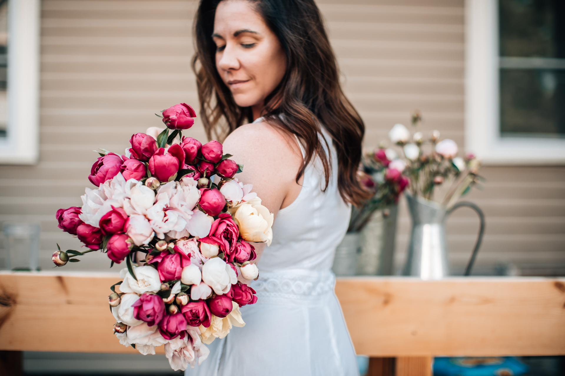 Caring for Peonies by popular New England blogger, Shannon Shipman: image of Shannon Shipman wearing a white dress and holding a bouquet of pink and white peonies. 